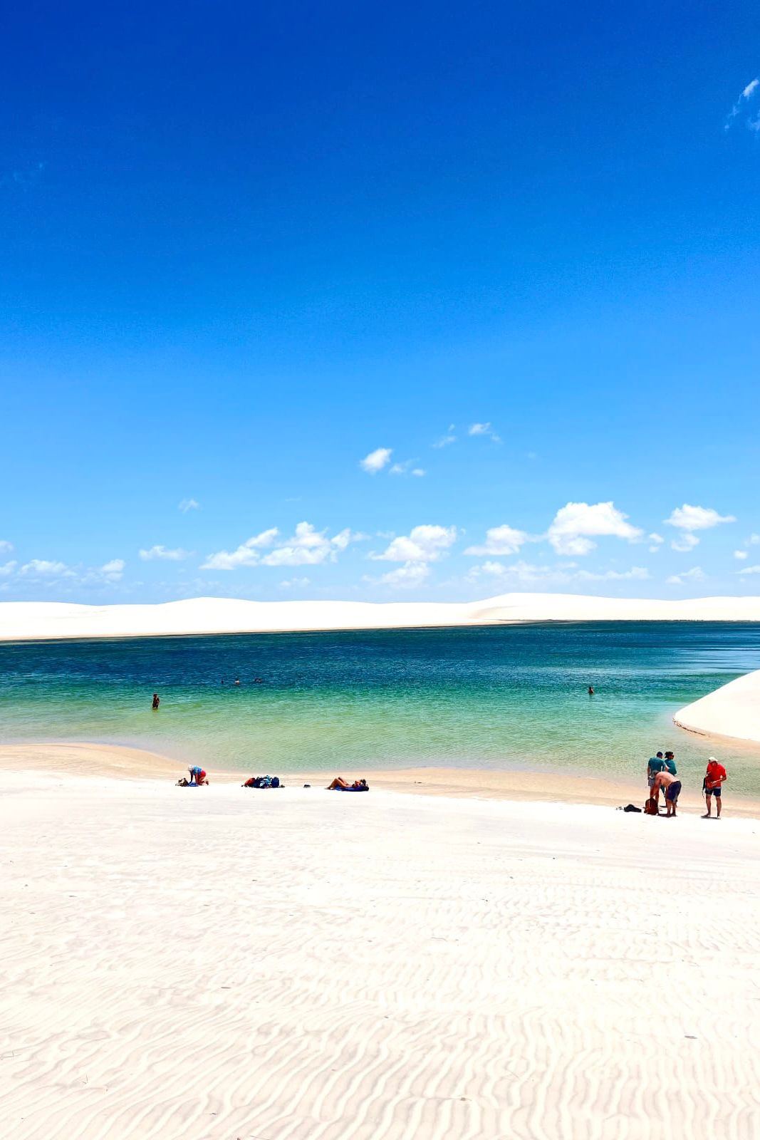 Lagoa de água verde e azul entre dunas brancas nos Lençóis Maranhenses